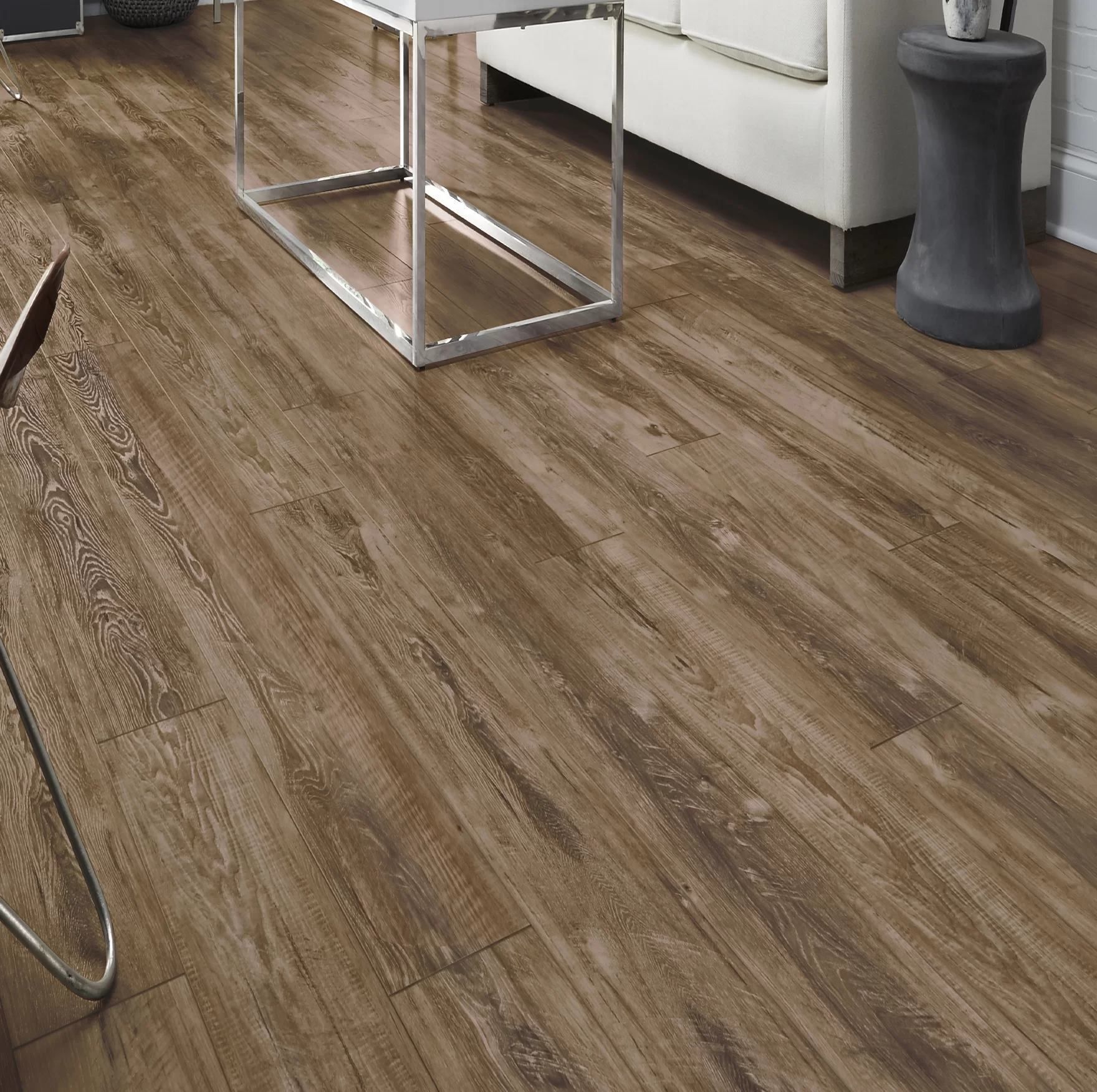 Wood-look flooring in a modern living room with a chrome table and white sofa.