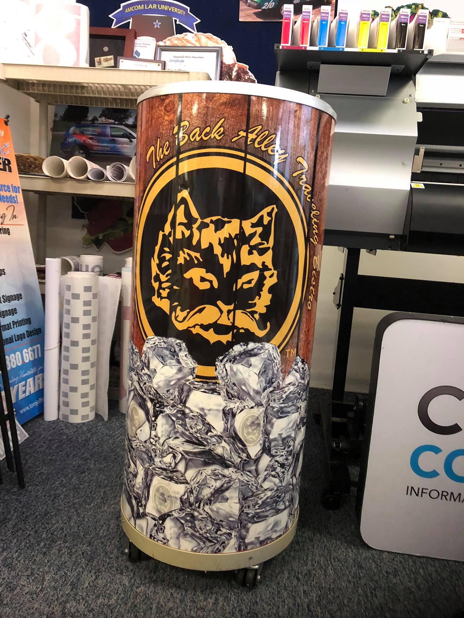 A cylinder with a cat on it is sitting in a room.