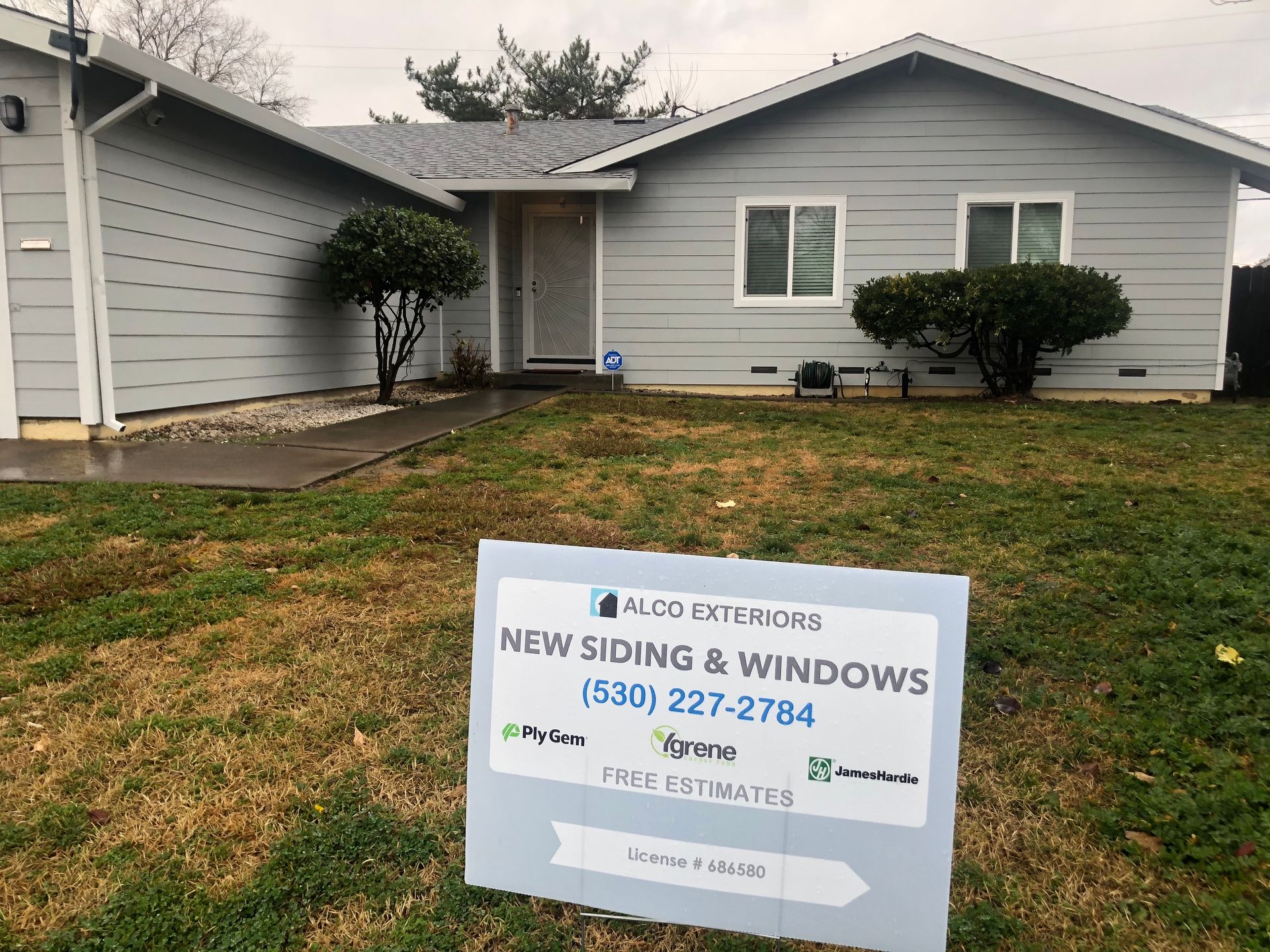 a house with a sign in front of it that says `` new siding & windows ''.