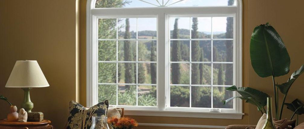 a living room with a large window and a lamp.