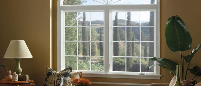 a living room with a large window and a lamp .