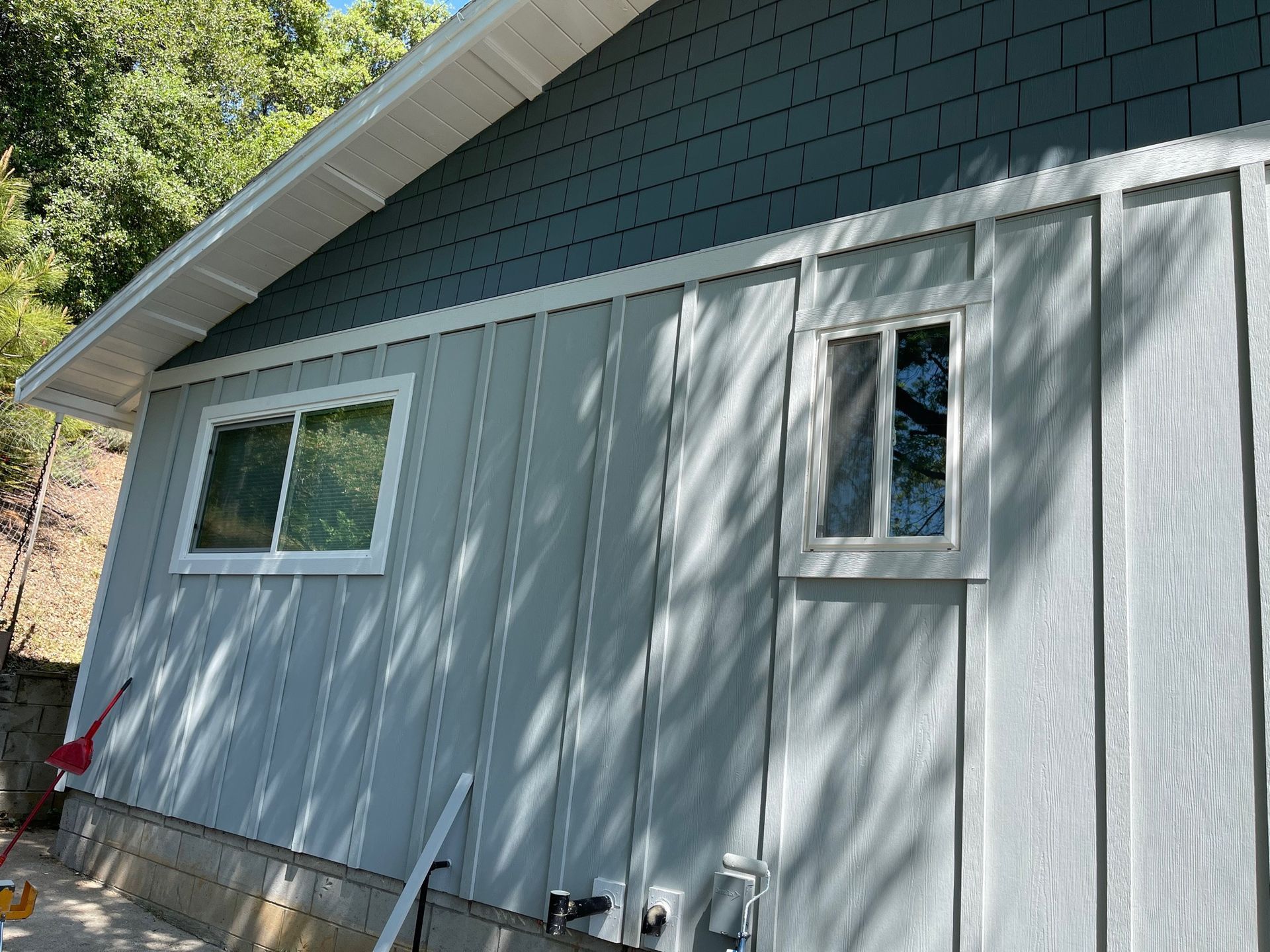 a gray house with a window on the side of it .
