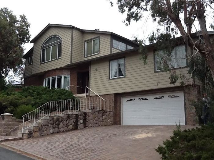 a large house with a white garage door and stairs