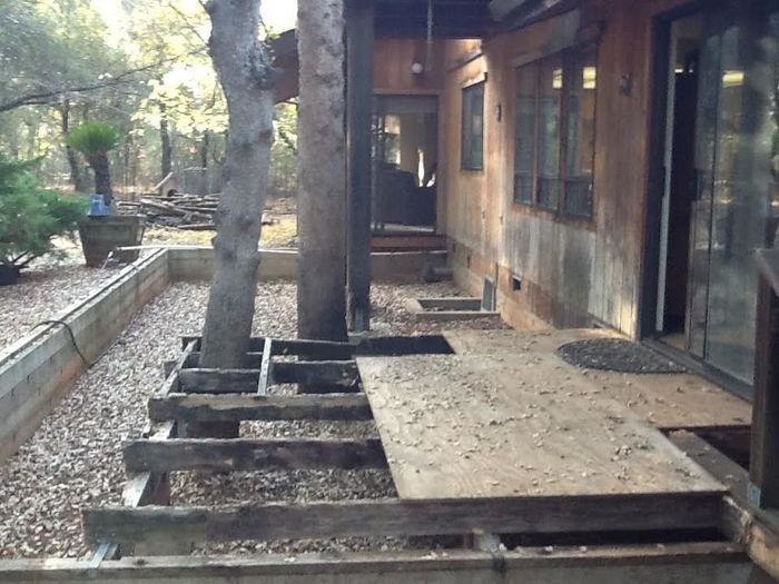 a wooden deck is being built in front of a house