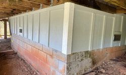 a brick wall with white siding.