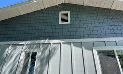 a close up of a house with a gray siding.