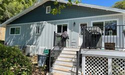 a small house with a deck and stairs.