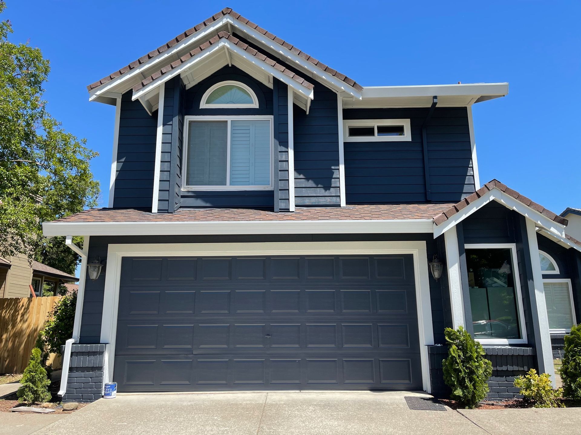 a blue and white house with a large garage door.