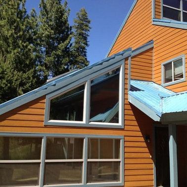 a house with a blue roof and a lot of windows