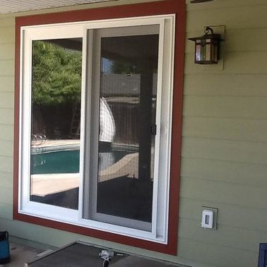 a sliding glass door with a screen on it is on a patio next to a pool.