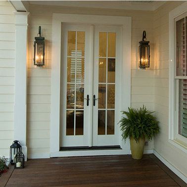 the front door of a house with a potted plant in front of it