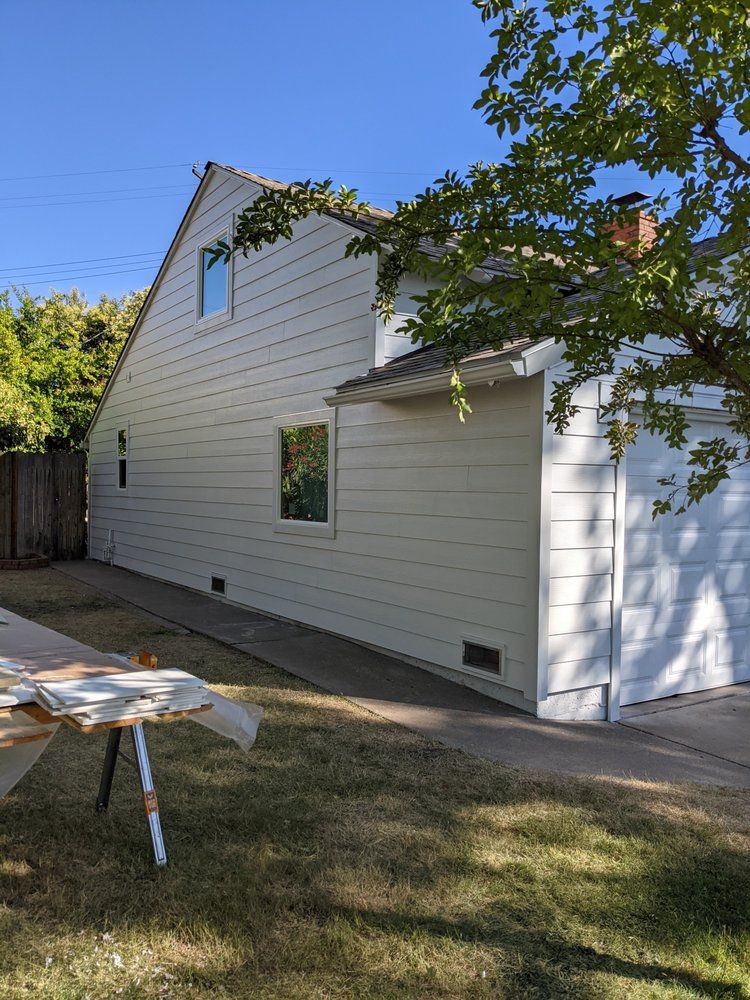 a white house with a garage and a table in front of it .