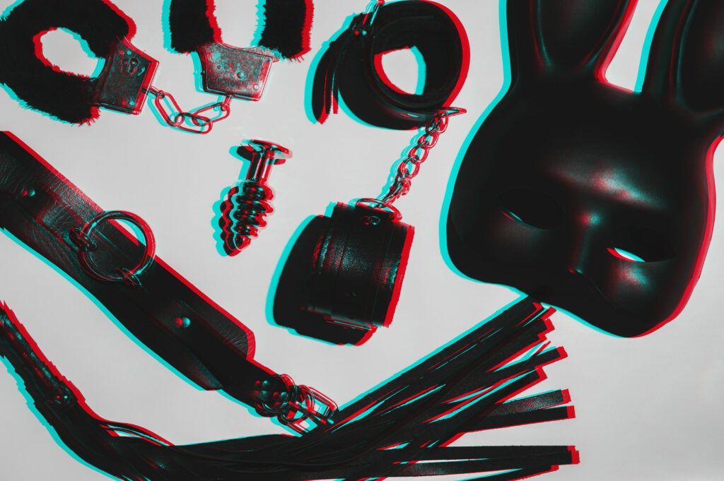 Picture of bondage items and sex toys on a white table