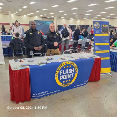 Fire department booth at a community event with two uniformed officers and a blue table display