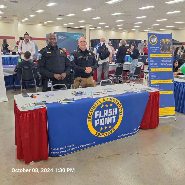 Fire department booth at a community event with two uniformed officers and a blue table display