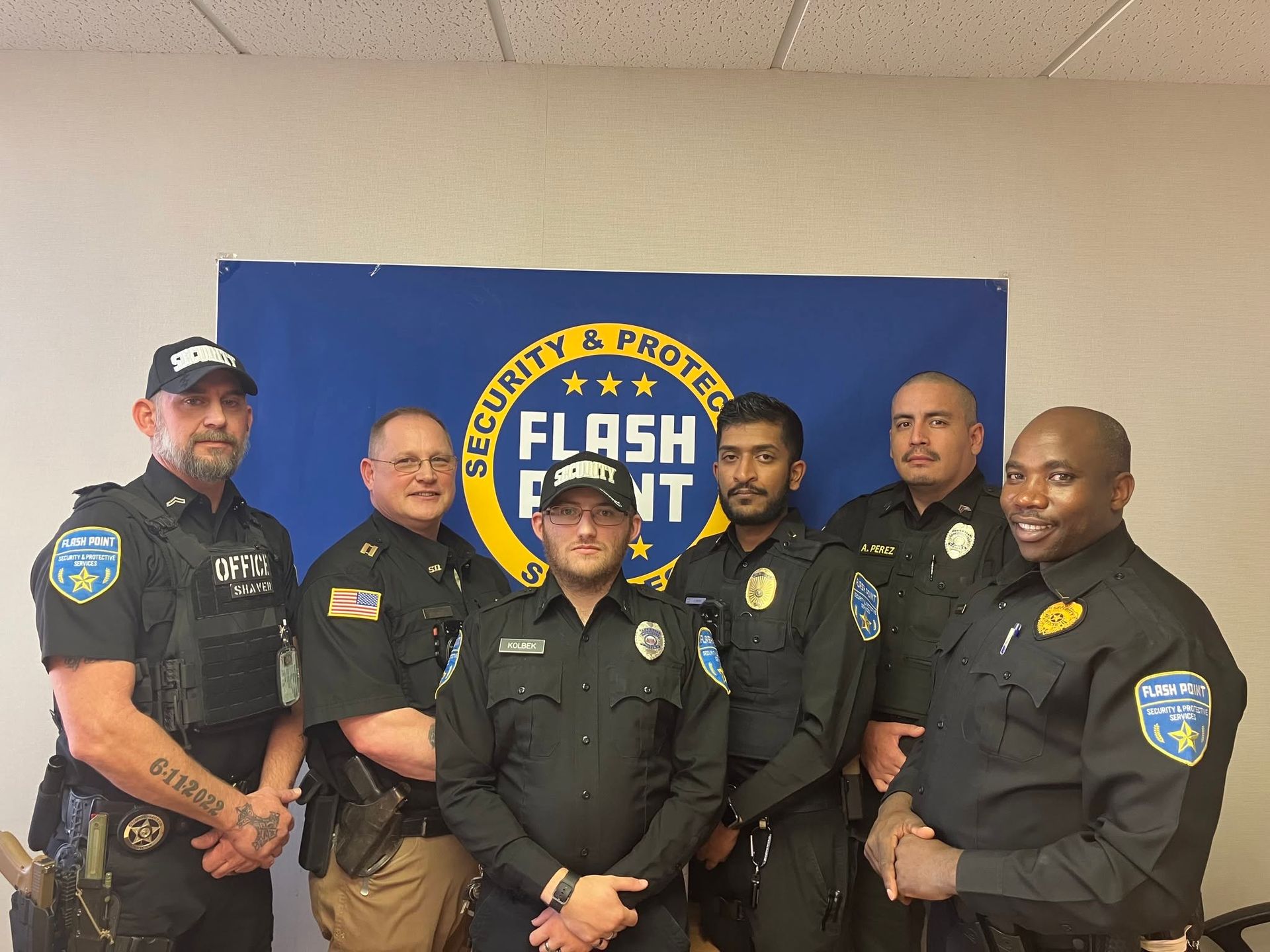 Six police officers in black uniforms posing in front of a blue “Flight Fight” banner.