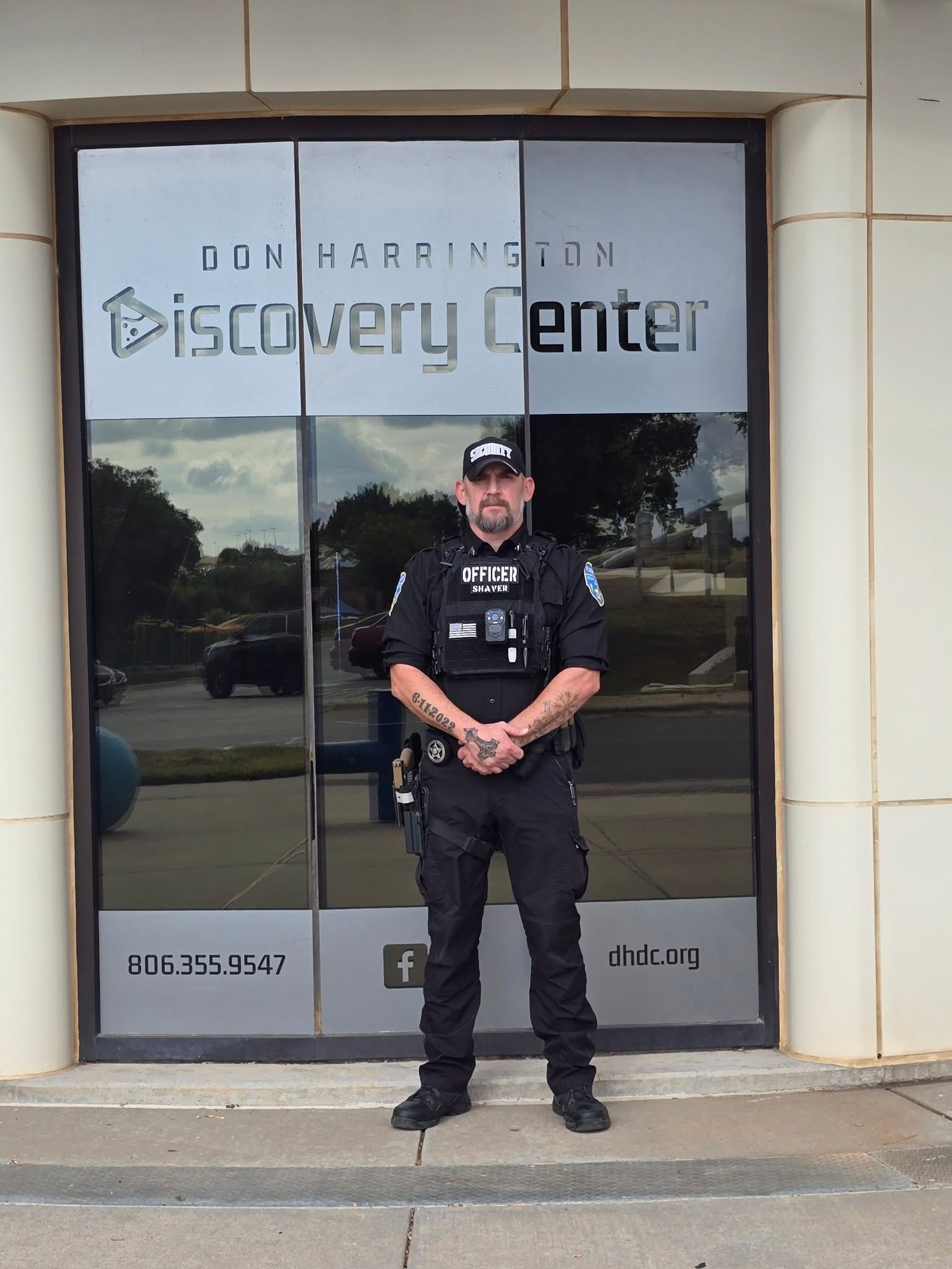 Security officer standing outside a Discovery Center entrance with glass doors.
