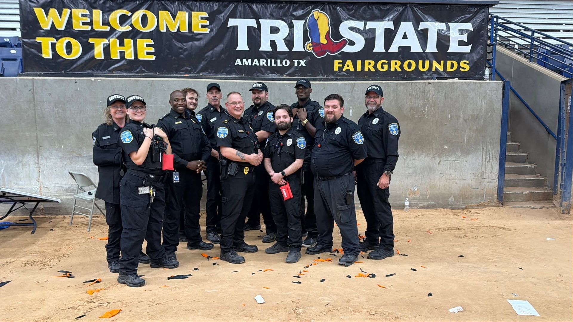Uniformed staff pose in front of a Tri-State Fairgrounds banner and “Welcome to the” sign.