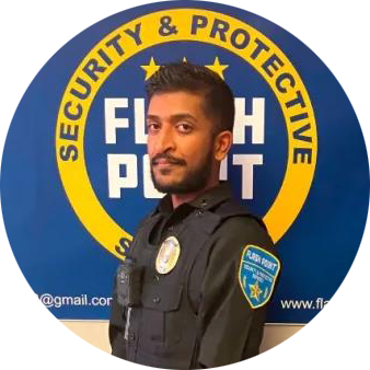 Security guard in black uniform standing before a blue-and-yellow Security & Protective shield logo