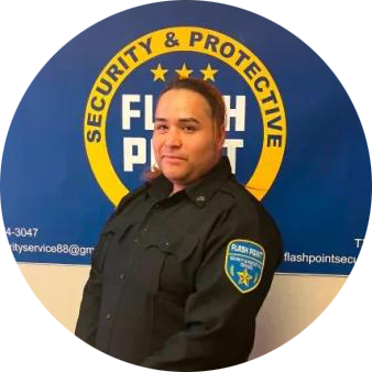 Person in black uniform standing before a blue and yellow SECURITY & PROTECTIVE sign.
