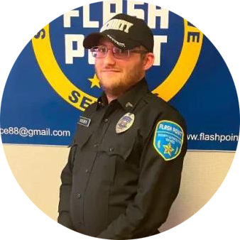 Security guard in black uniform and cap standing before a blue Flashpoint sign