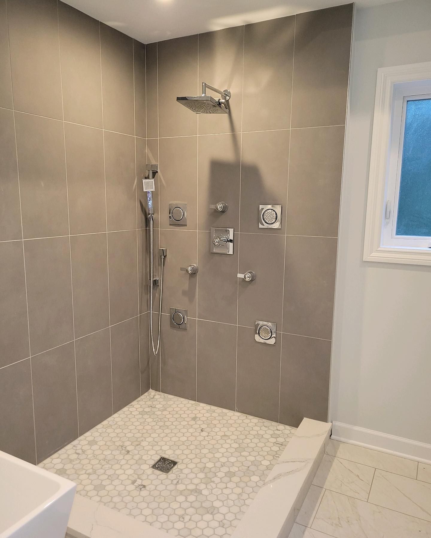 New shower faucet installation with custom tile and luxury plumbing fixtures
