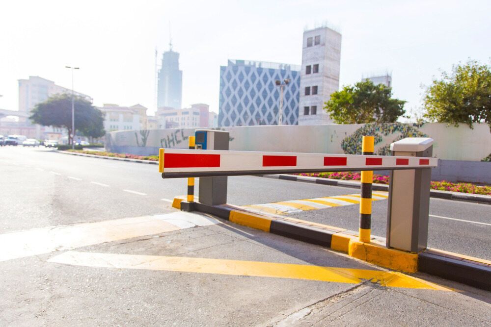 A Barrier Is Blocking The Entrance To A Parking Lot In A City — Fortress Locksmiths & Security in Hornsby, NSW