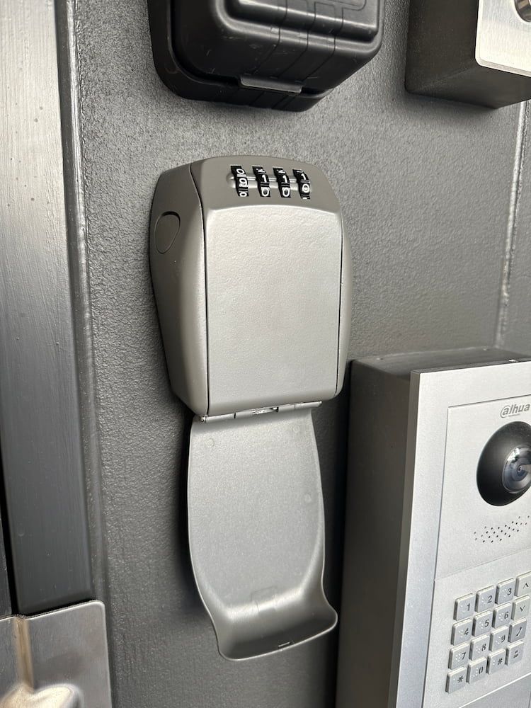 A Key Box Is Sitting On A Wall Next To A Keypad — Fortress Locksmiths & Security in St Ives, NSW