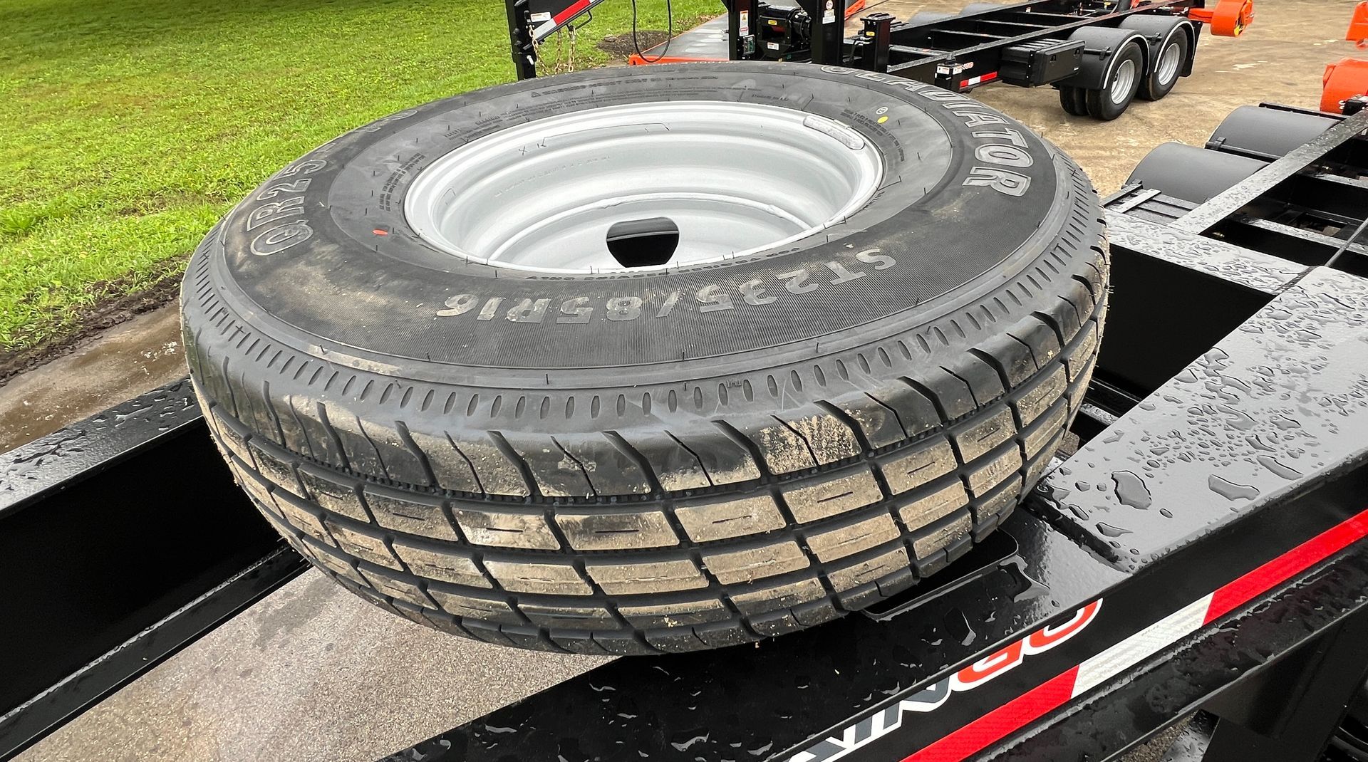 A tire is sitting on top of a trailer.