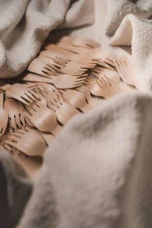 Close-up of tan paper with laser-cut slits, nestled in a soft beige blanket.