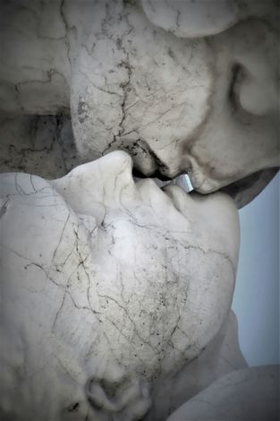 Two cracked white plaster faces pressed together, one above the other