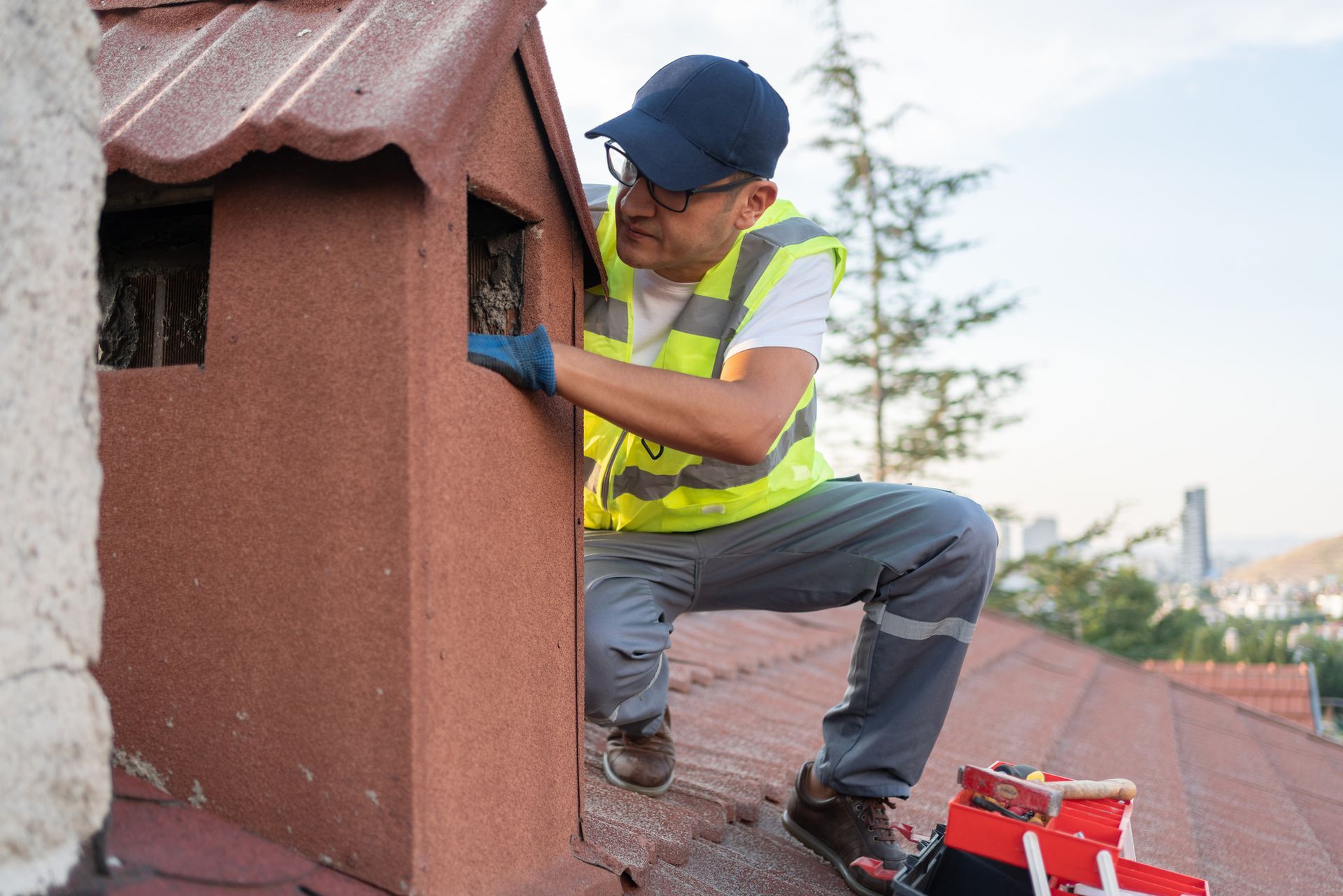 A contractor providing chimney sweeping services on the roof of a house. 