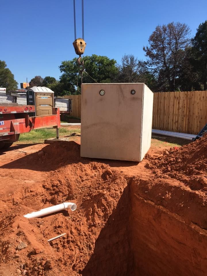 A large concrete block is being lifted by a crane