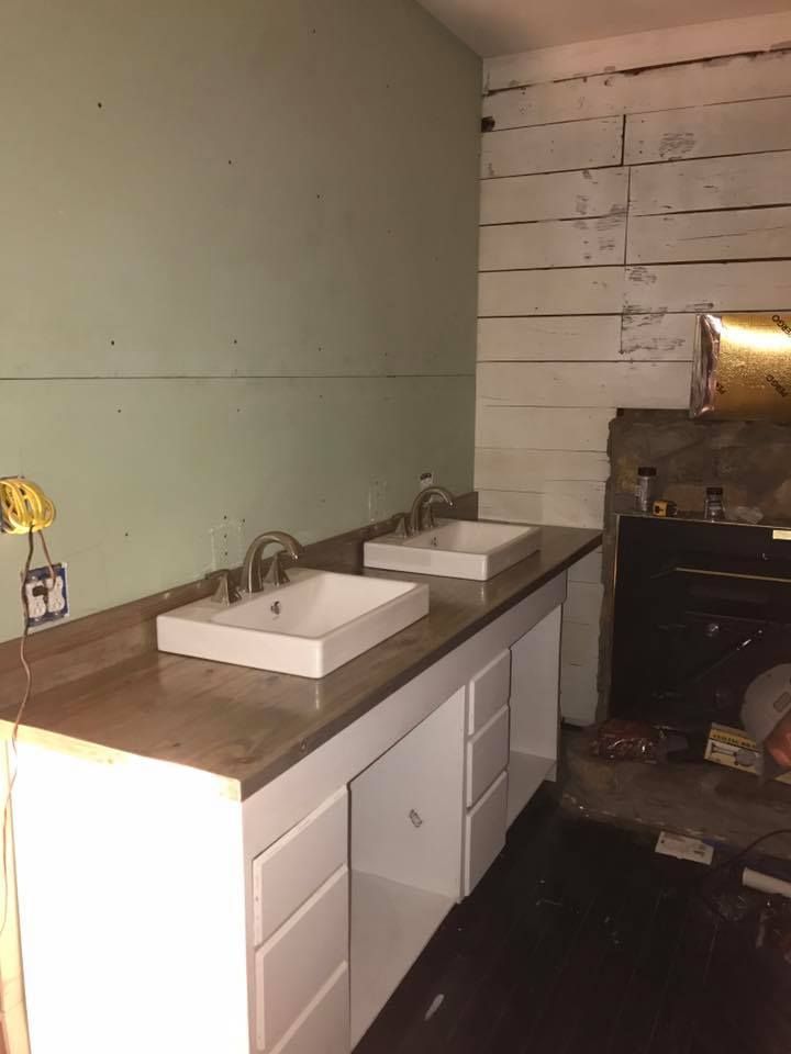 A bathroom with two sinks and a fireplace