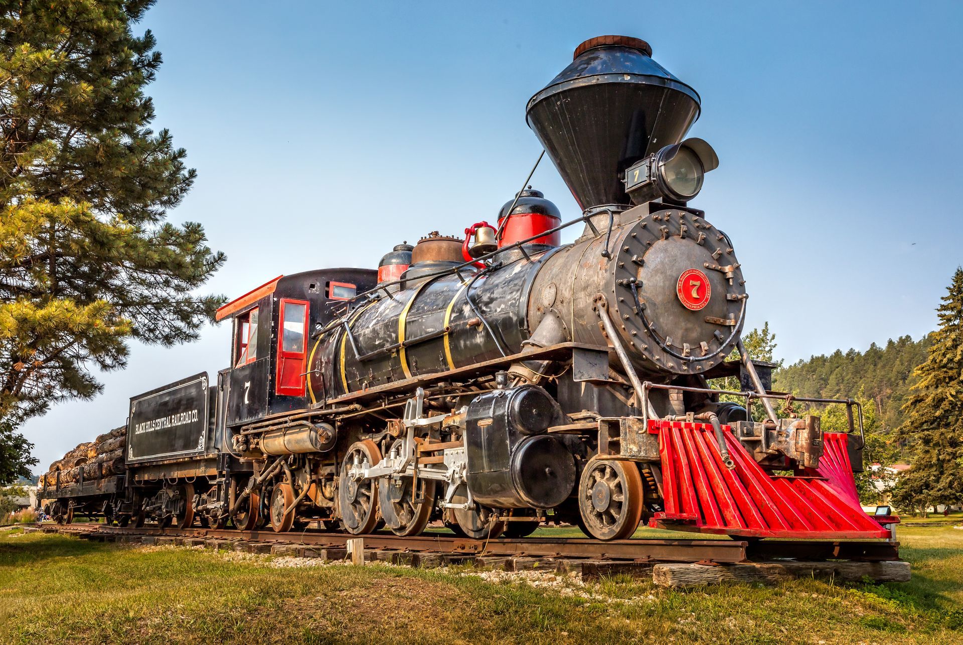 an old train is parked on the tracks in a field .