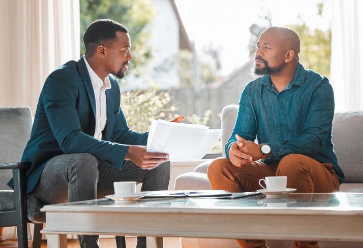One man giving another advice over a cup of coffee