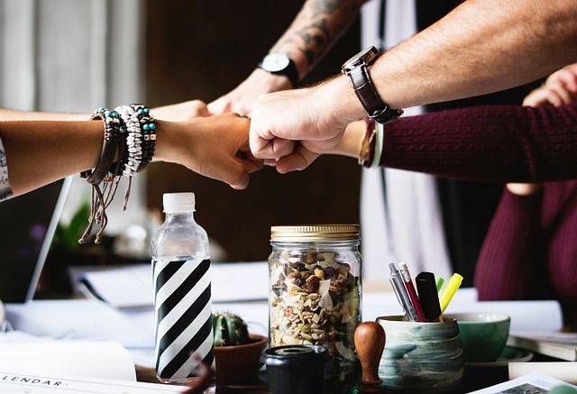 Team fist-bumping over conference room table