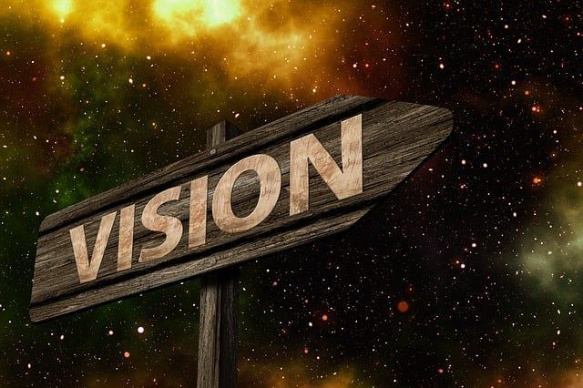 IMAGE OF A SIGNPOST THAT SAYS VISION; STARS IN THE BACKGROUND