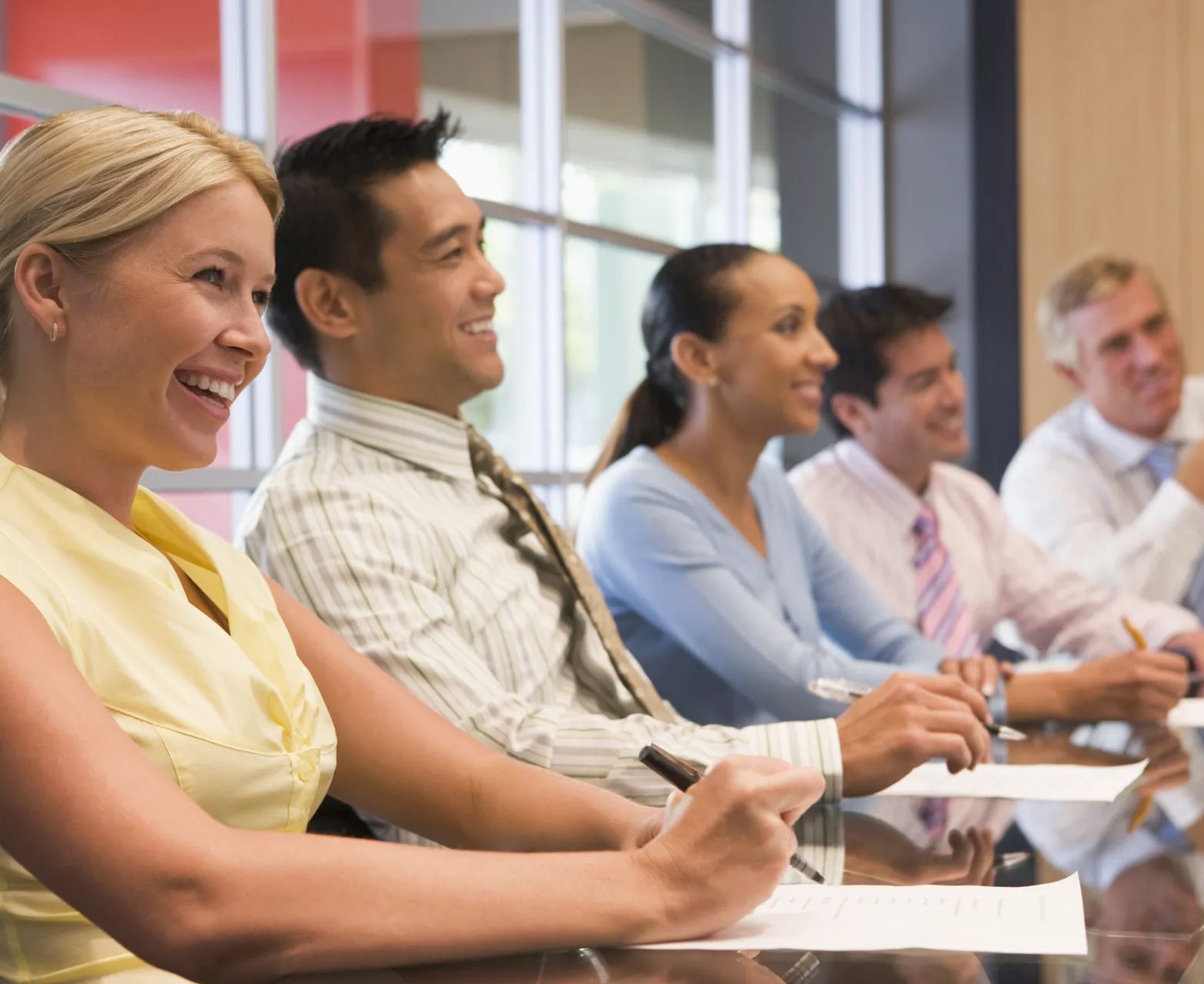 A group of people are sitting at a table in a conference room.