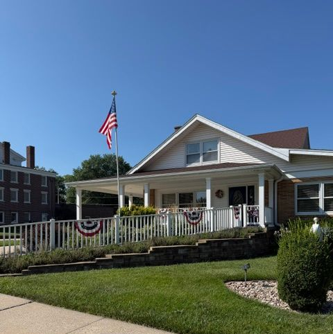 House decorated with patriotic bunting and an American flag on a sunny day