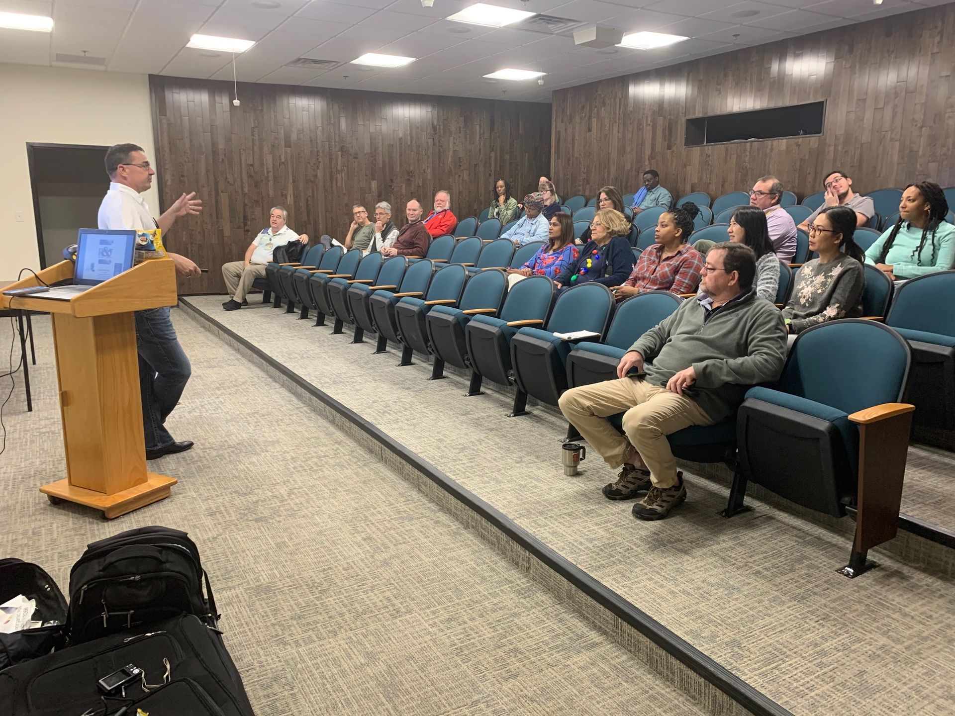 A man is giving a presentation to a group of people in an auditorium.