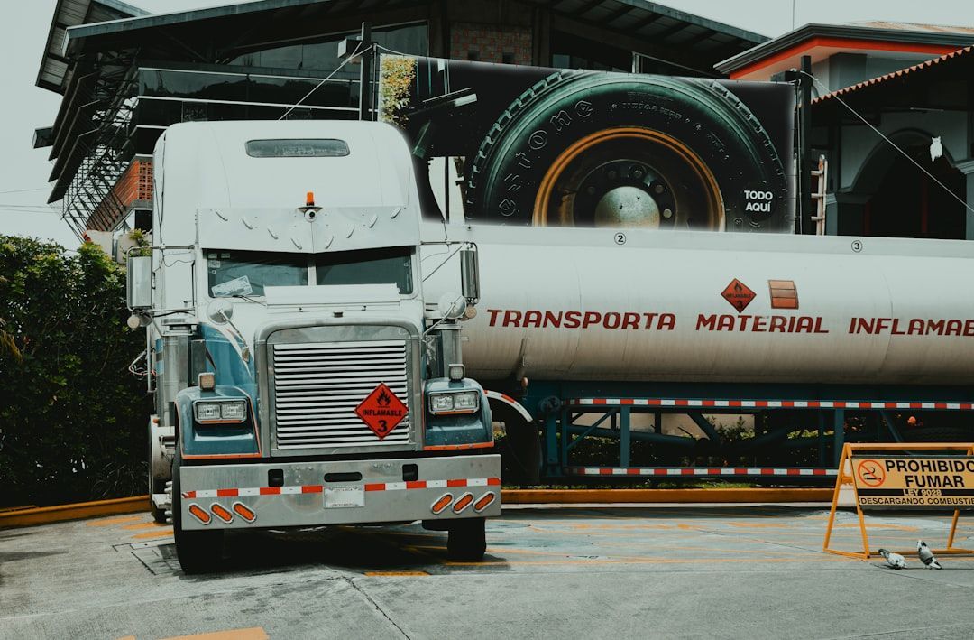 A semi truck is parked in front of a building.
