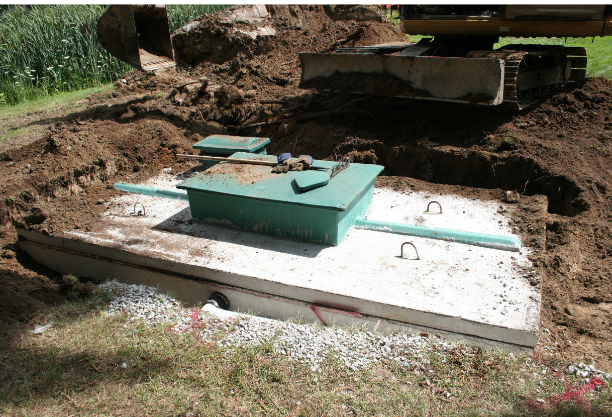 a green box sits in the dirt next to a bulldozer