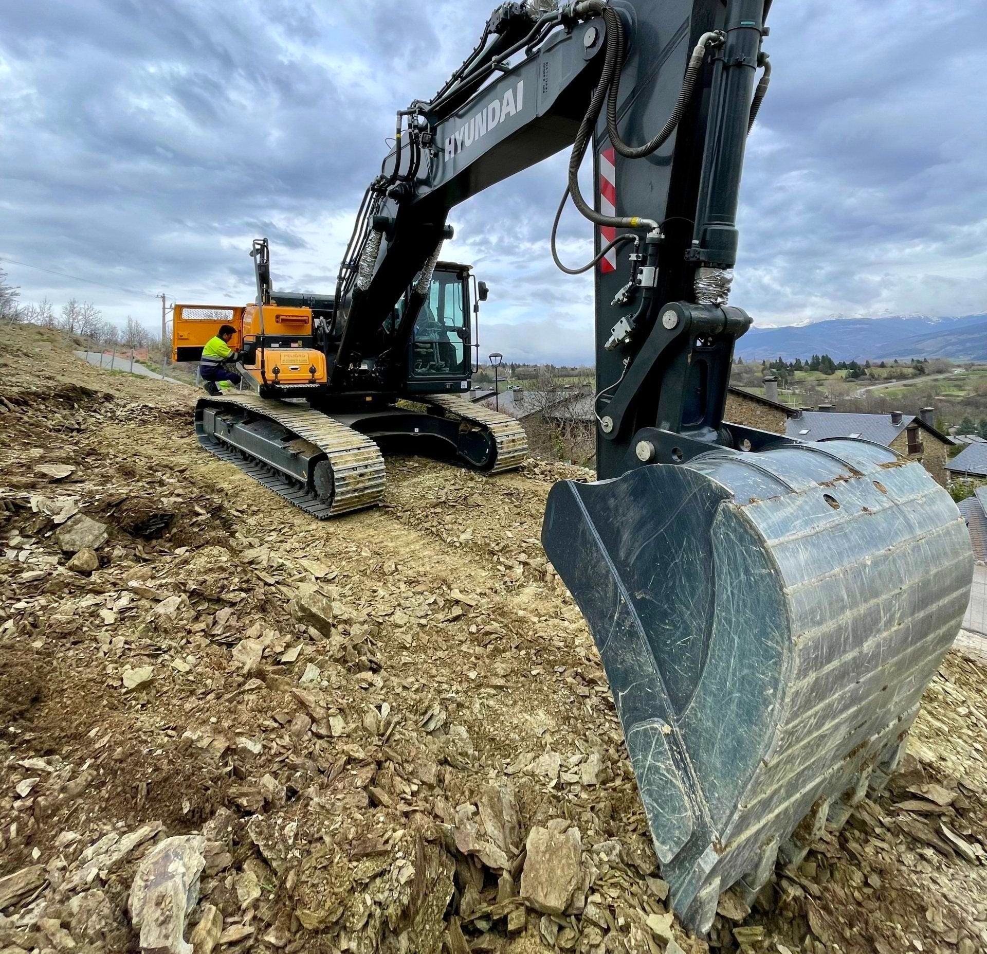 a hyundai excavator is on a rocky hillside