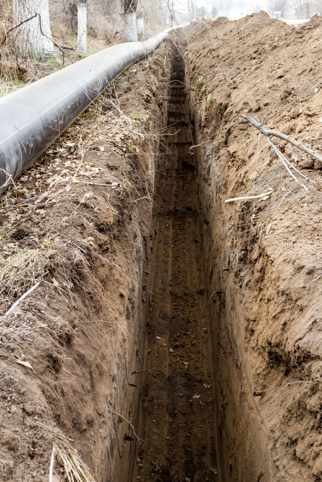 a trench with a black pipe in the background