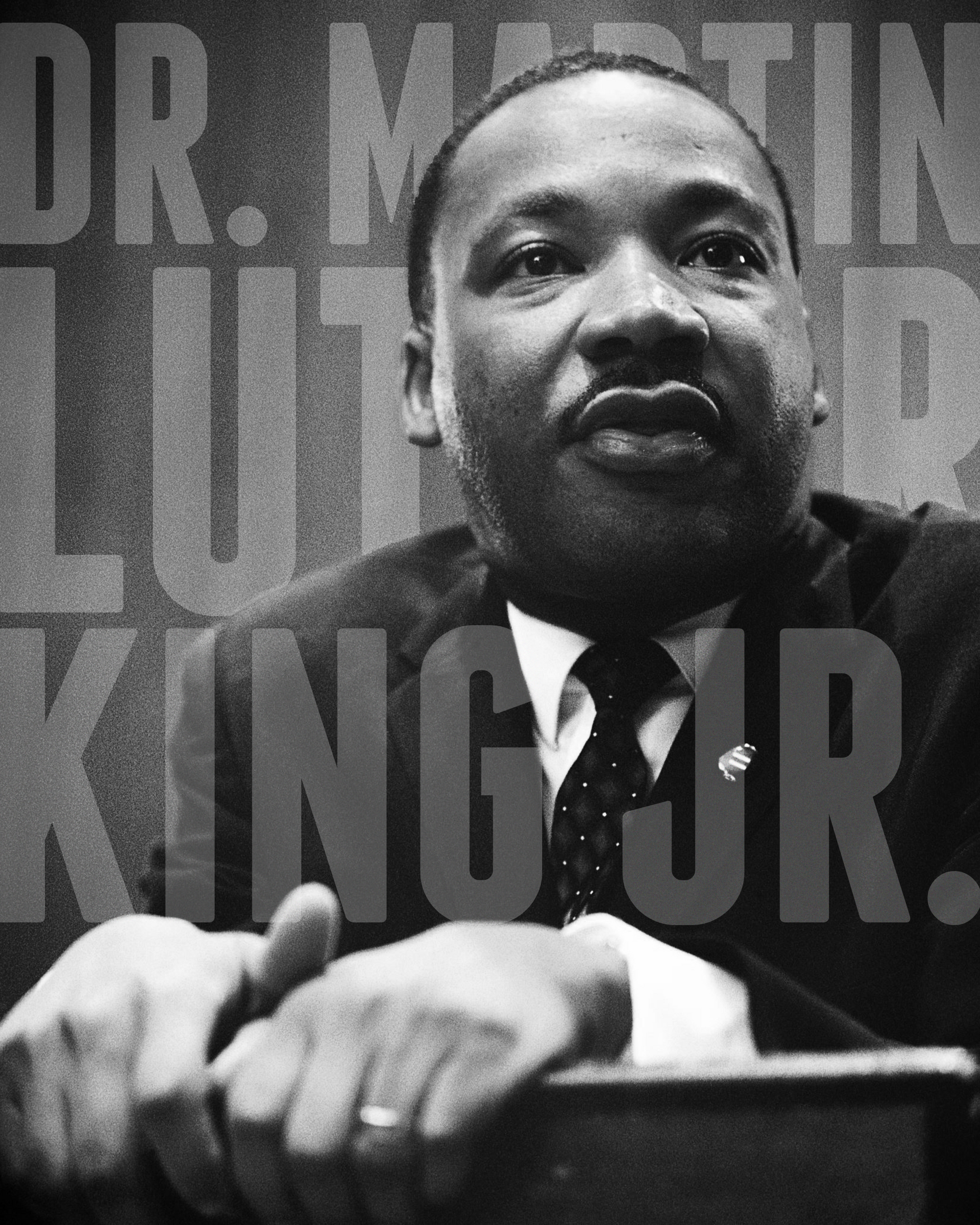 Black-and-white portrait of Dr. Martin Luther King Jr. speaking at a podium, with his name faintly in the background