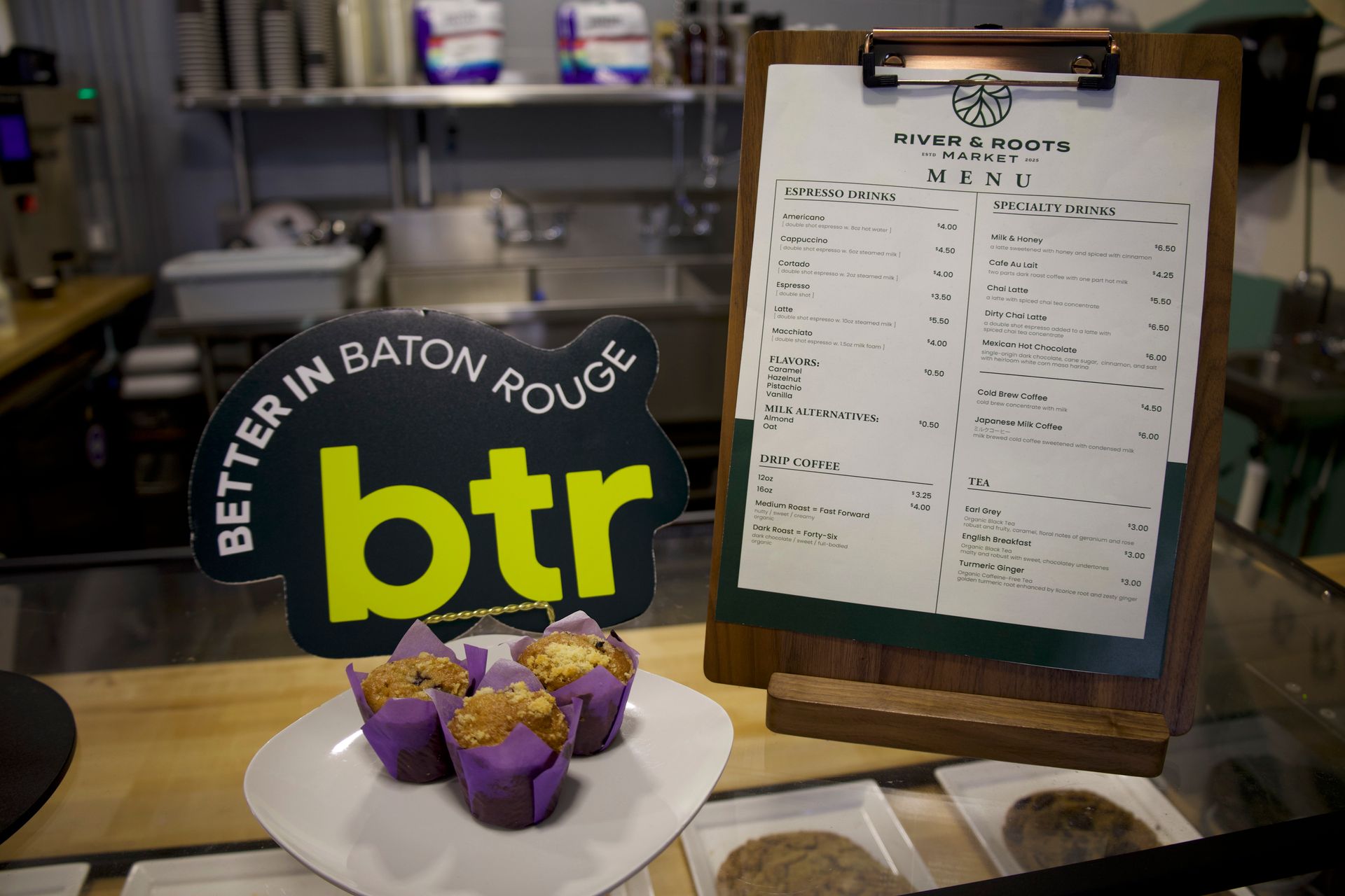 Bakery display with purple-topped treats, a “btr” sign, and a menu on a clipboard