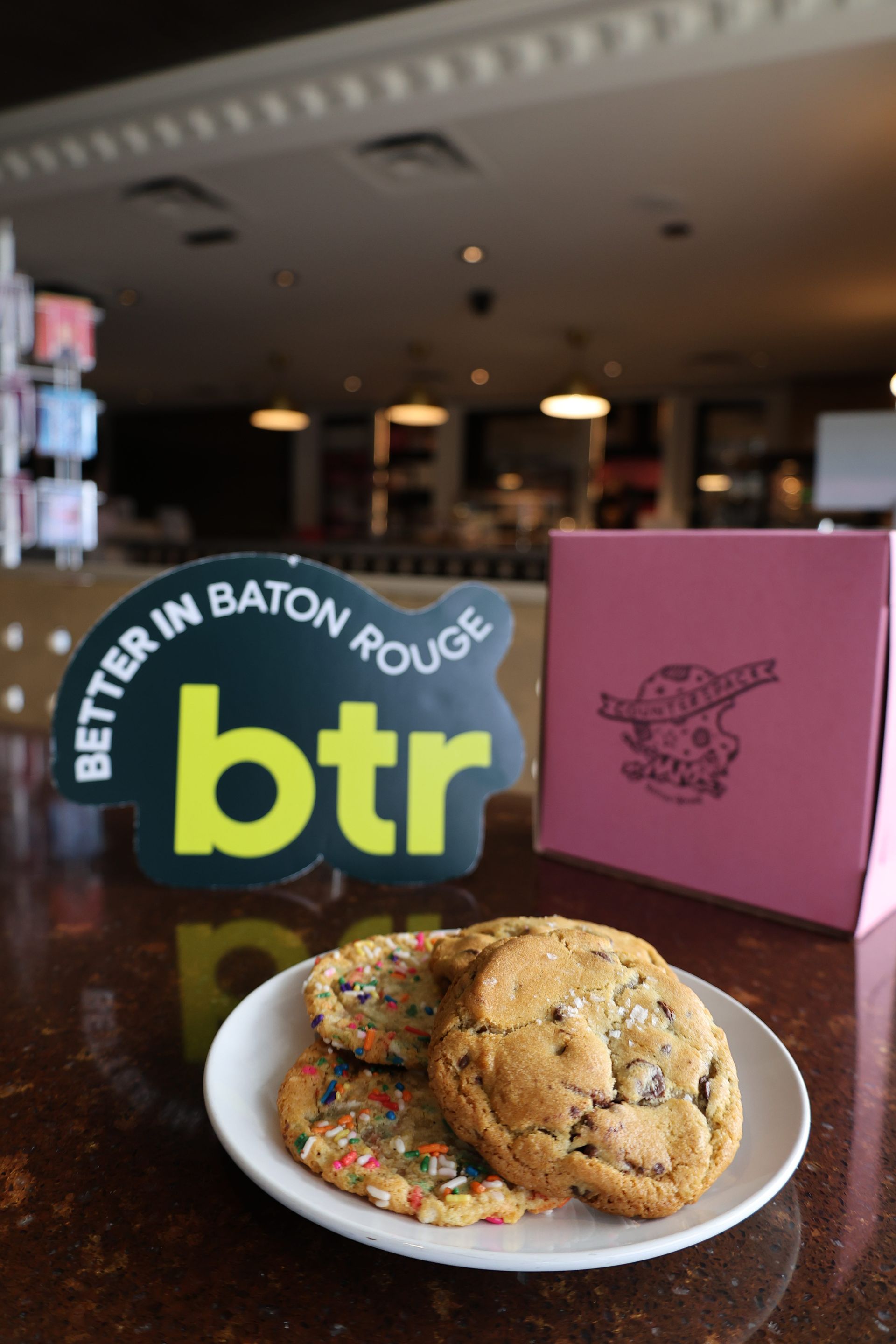 Dessert plate with two cookies beside a BTR Baton Rouge sign on a restaurant table