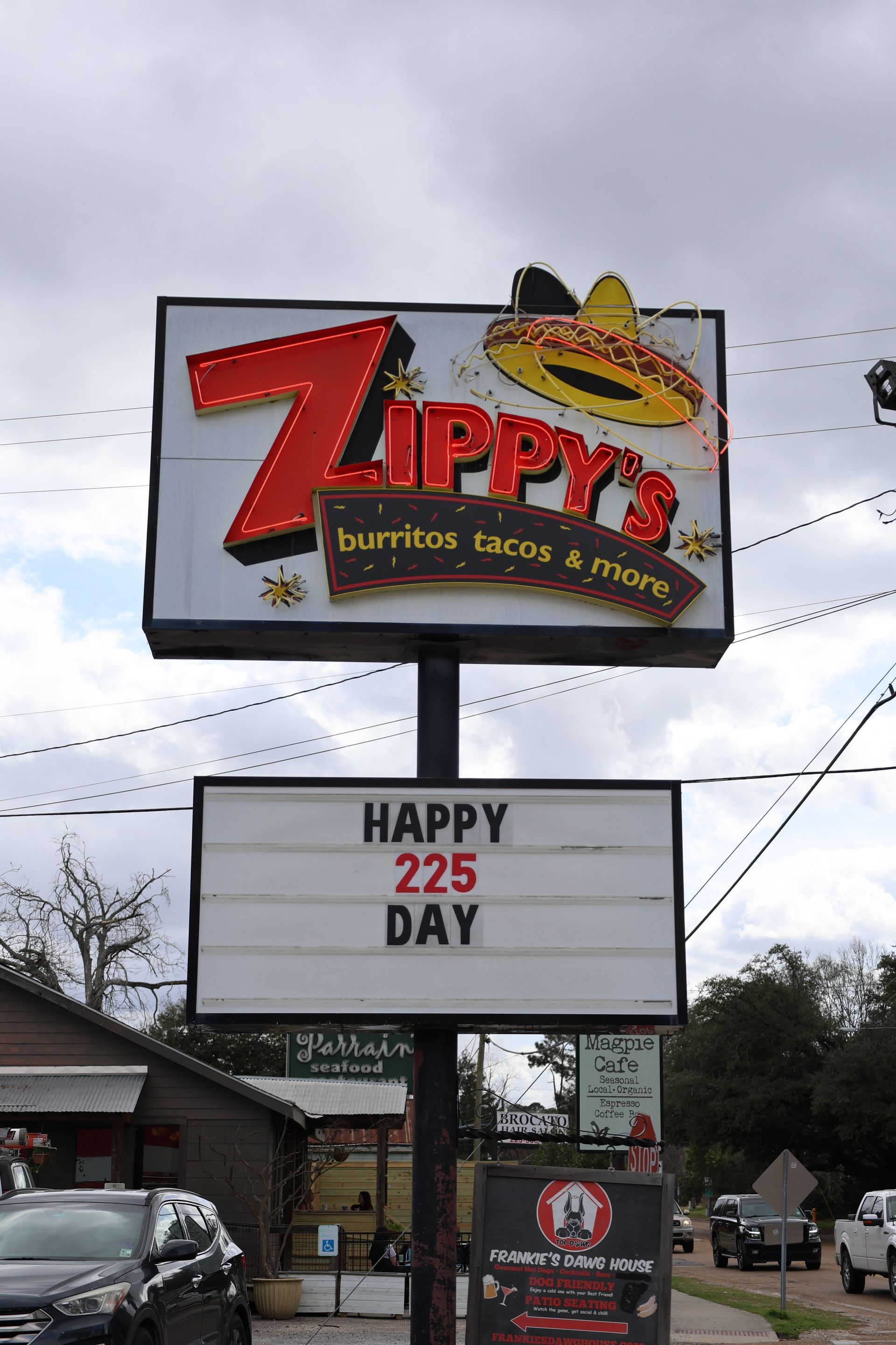 Zippy’s burritos, tacos & more roadside sign with “Happy 225 Day” message under a cloudy sky