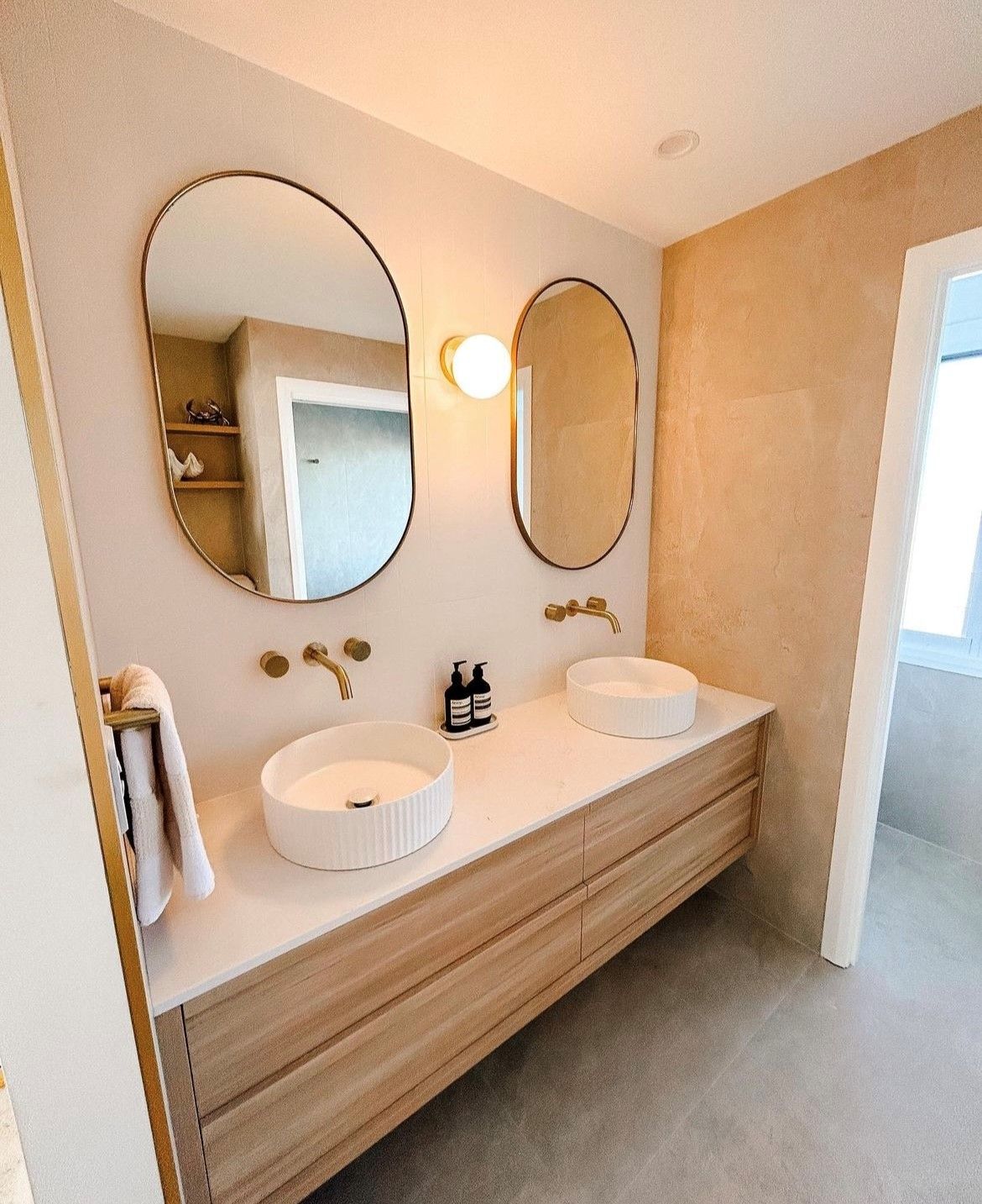 Modern bathroom with wooden vanity, two oval mirrors, and vessel sinks — Tile Trends in Tweed Heads South, NSW